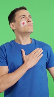 Stüdyoda, Japon milli marşını dinleyen bir adamın krom renkli videosu.
