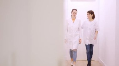Klinikteki meslektaşı tarafından desteklenen endişeli bir kadın doktorun yavaş çekim videosu.