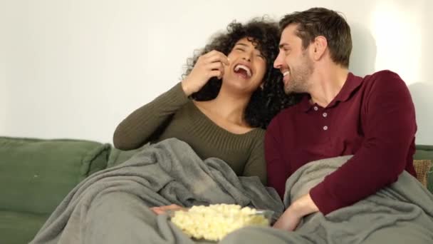 自宅で映画を見ているポップコーンを食べて笑う多民族カップルのスローモーションビデオ — ストック動画