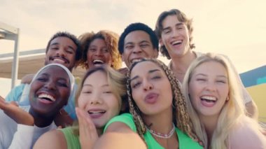 Saçları örgülü Latin bir kadının çok ırklı arkadaşlarıyla dışarıda selfie çektiği yavaş çekim videosu.