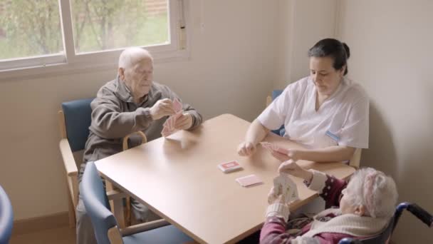 长者及照顾者在疗养院打牌的慢动作视频 — 图库视频影像