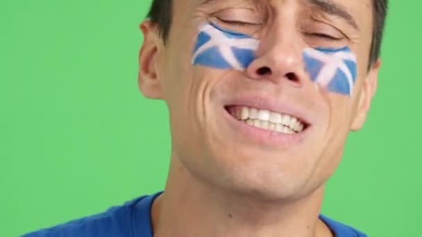 Закрыть Видео Студии Хромой Нервного Человека Нарисованным Лице Шотландским Флагом — стоковое видео