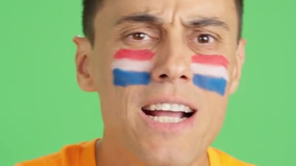 オランダチームをサポートする顔にオランダの旗を塗った男のクロマのスタジオでのビデオ — ストック動画