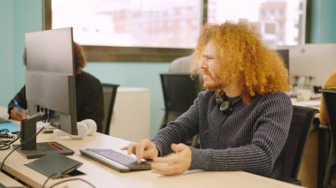 Bir iş yerinde bilgisayar sorunu yaşayan kızgın bir işçi