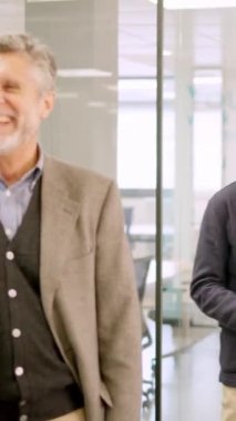 İki yetişkin iş adamının iş yerinde mutlu bir şekilde gülümsediği yavaş çekim videosu.