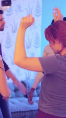 Bir grup çok ırklı arkadaşın dairede dans edip parti yapmasının yavaş çekim videosu.