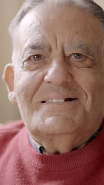 Huzurevinde kameraya gülümseyen yaşlı bir adamın yavaş çekim videosu.