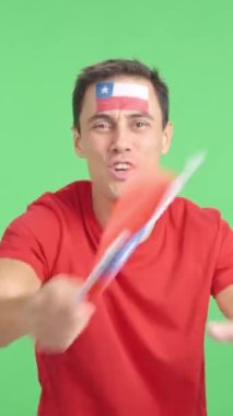 Stüdyoda, Şili 'yi coşkuyla alkışlayan ve ulusal bayrak sallayan bir adamın krom görüntüsü var.