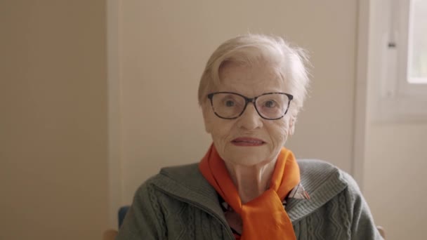 一个老年妇女坐在疗养院里看着摄像机的慢镜头 — 图库视频影像
