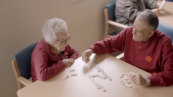 一个老年人和老朋友在老年病中玩多米诺骨牌的慢镜头 — 图库视频影像