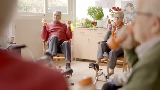 使用哑铃和踏板在养老院进行锻炼的一组老年男女的慢镜头 — 图库视频影像