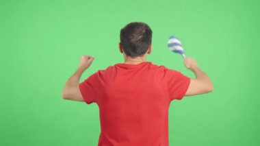 Stüdyoda Küba flaması sallayan bir adamın dikiz aynasından krom görüntüler var.