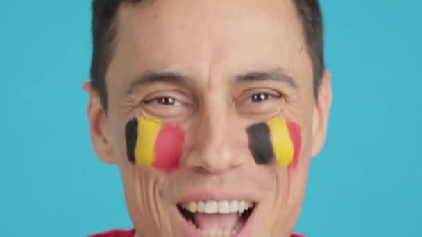 摄影棚里的录像 彩色的是一个男人的特写镜头 他的脸上挂着一面支持伯利兹队的伯利兹国旗 — 图库视频影像