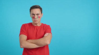 Stüdyoda, yüzünde Portekiz bayrağı olan ağırbaşlı ve ciddi bir adamın rengiyle kameraya haysiyetle bakan bir adamın videosu var.