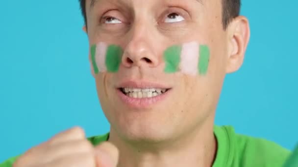 在演播室里用彩色的特写拍摄了一个非常紧张的男人 他的脸上挂着一面尼德兰国旗 在一场最后以失败告终的艰难的比赛中 他支持了尼德兰队 — 图库视频影像