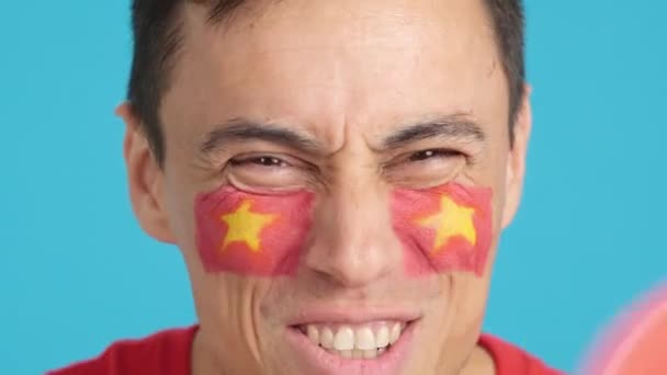 工作室里的录像 彩色的是一个男子的特写镜头 他的脸上挂着越南国旗 支持着越南团队 — 图库视频影像