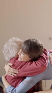 Yaşlı bir torunun büyükannesini kucakladığı yavaş çekim videosu.