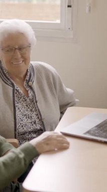 Yaşlılarda dizüstü bilgisayarla video görüşmesi yapan iki yaşlı insanın yavaş çekim videosu.