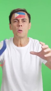 Stüdyoda, hakemlerin kararına kızgın, elinde Filipin bayrağı sallayan bir adamın krom görüntüsü var.