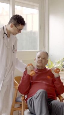Bir fizyoterapistin huzur evinde bir asistanla nazikçe konuşmasının yavaş çekim videosu.