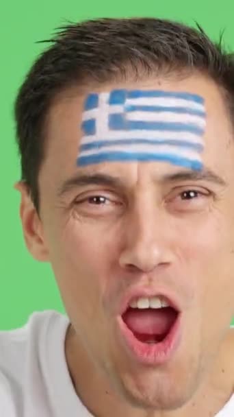 摄影棚里的录像 彩色的是一个男人的特写镜头 他的脸上挂着希腊国旗 支持希腊球队 — 图库视频影像