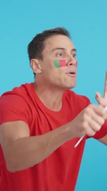 Stüdyoda, elinde Portekiz bayrağı sallayan, hakemlerin kararına kızgın bir adamın krom görüntüsü var.