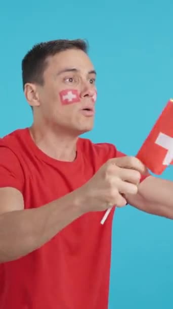 스위스 국기를 흔들며 멀리보고있는 남자의 크로마와 스튜디오에서 비디오 결정과 — 비디오