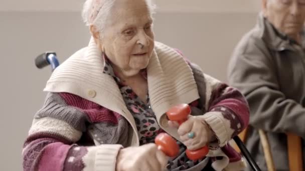 Медленное Видео Пожилой Женщины Тренирующейся Гантелями Сидящей Доме Престарелых — стоковое видео