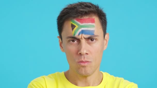 카메라를 얼굴에 그려진 남아프리카 깃발을 심각한 남자의 클로즈업의 크로마와 스튜디오에서 — 비디오