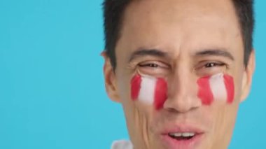 Stüdyoda, yüzünde Peru bayrağı olan ve Peru takımını destekleyen bir adamın krom görüntüsü var.