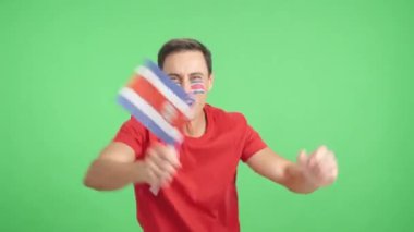 Stüdyoda, Kosta Rika için coşkuyla tezahürat eden ve ulusal bayrak sallayan bir adamın krom klibi var.