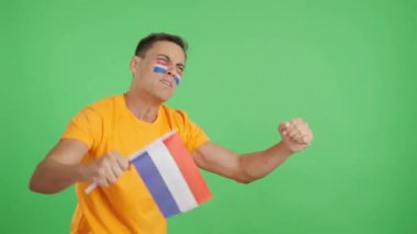 Flaman ulusal bayrağını sallayan, hakemlerin kararına kızgın bir adamın kromasıyla stüdyoda bir video.