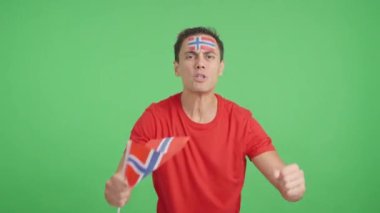 Stüdyoda, hakemlerin kararına kızgın bir şekilde Norveç bayrağı sallayan bir adamın kromasıyla.