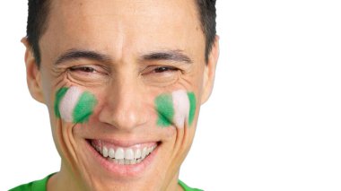 Yüzünde Nijerya bayrağı olan ve kameraya gülümseyen bir adama yaklaş.