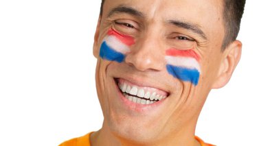 Kameraya gülümseyen, yüzünde Hollanda bayrağı olan bir adama yaklaş.