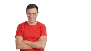 Yüzünde İsviçre bayrağı olan adam kollarını kavuşturup gülümsüyor.