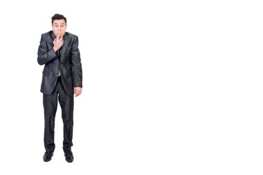 Zarif takım elbiseli, ağzı parmaklarla kaplayan ve beyaz arka planda izole edilmiş kameraya bakan sakince saklanmış bir adam.