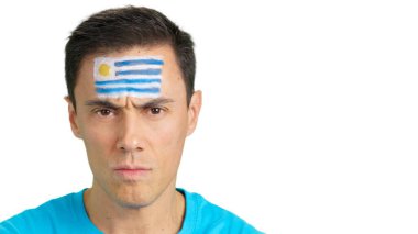 Yüzünde Uruguay bayrağı olan ve kameraya bakan ciddi bir adama yaklaş.