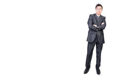 Şaşkın, siyah saçlı, zarif takım elbiseli, beyaz arka planda kolları çapraz duran ve kuşkuyla başka yöne bakan bir erkek çalışanın tüm vücudu.