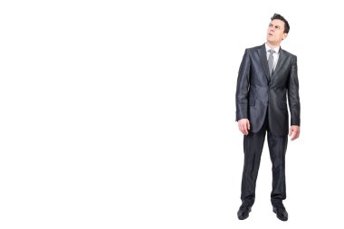 Full body of skeptic male entrepreneur grimacing and looking up while expressing mistrust on white background in studio clipart