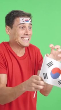 Stüdyoda, gergin bir adamın Güney Kore 'ye tezahürat ettiği bir krom krom var.