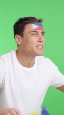 Stüdyoda, elinde Filipin Ulusal Bayrağı sallayan, hakemlerin kararına kızgın bir adamın krom görüntüsü var.