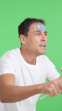 Stüdyoda, hakemlerin kararına kızgın bir şekilde elinde ulusal bayrak sallayan bir adamın krom görüntüsü var.