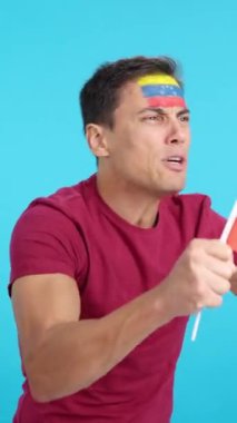 Stüdyoda, Venezuela ulusal bayrağını sallayan, hakemlerin kararına kızgın bir adamın krom görüntüsü var.