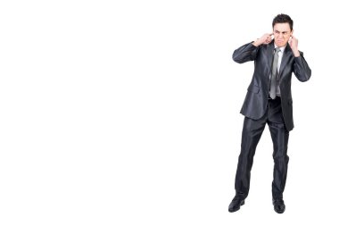 Kızgınlığını ifade eden resmi takım elbiseli kızgın erkek yöneticinin tüm vücudu ve beyaz arka plana karşı stüdyodaki gürültüden kulaklarını kapatıyor.