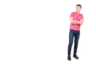 Full body of surprised male in casual wear with opened mouth and crossed arms standing on isolated white background in light studio clipart