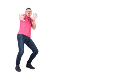 Kot pantolonlu ve pembe tişörtlü korkunç bir erkek koruyucu jest yapıyor ve kameraya bakarken panik içinde bağırıyor ve beyaz arka planda tek başına sendeleyerek geri dönüyor.