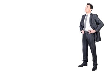 Resmi takım elbiseli mutlu bir erkek bedeni kameraya bakıyor. Gülümsüyor ve elleri belinde. Beyaz arka planda izole edilmiş.