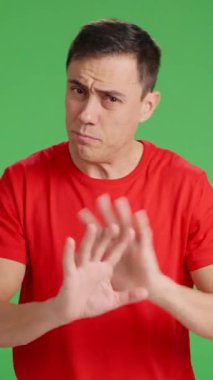 Sıkılmış adam esniyor ve biri onunla konuşurken dikkati dağılıyor, yeşil ekranda izole bir şekilde.