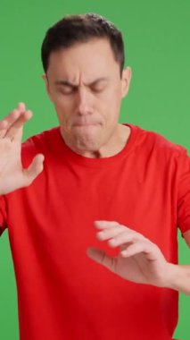 Bir yere nasıl gideceğini soran ve cevap verirken kafası karışan bir adam. Orta çekim, kırmızı tişört ve yeşil krom anahtar arka plan..